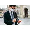 Elegant business man with protective face mask using alcohol spr